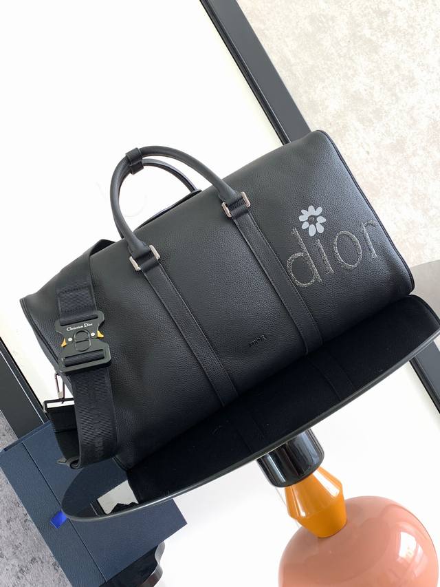 这款 Dior Lingot 50 行李袋是本季的主打单品 来自 Dior By Erl 联名系列 实用优雅 别具一格 采用黑色粒面牛皮革精心制作 正面饰以 D