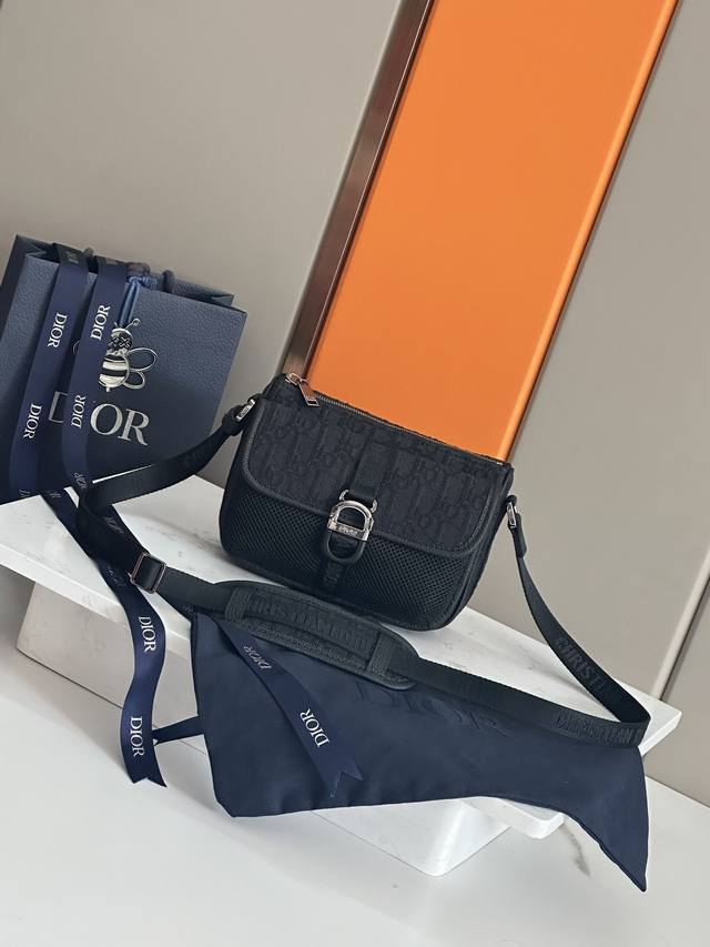 这款 Dior 8 手袋附有肩带 于二零二三秋季男装系列全新推出 别具一格的设计彰显现代魅力和简约美学 采用米色和黑色 Oblique 印花面料精心制作 刚性设