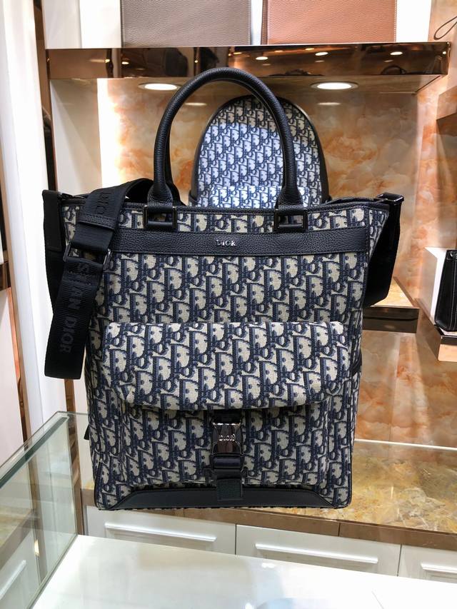 型号:706 Dior-迪奥专柜最新款男士手提包 购物袋官网同步 原单品质 这款手提袋是本季新品 采用米色和黑色oblique 印花面料精心制作 搭配奢华的黑色