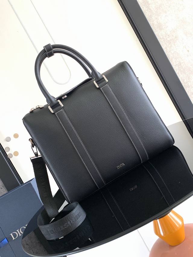 这款公文包是 Dior Lingot 系列的新款单品 将经典优雅与 Dior 的高订精神融为一体 结构分明 采用黑色粒面牛皮革精心制作 搭配对比鲜明的缉面线 正