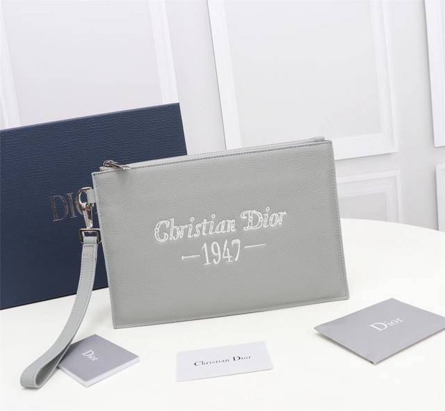 这款 A5 手拿包是一款优雅简约的配饰 采用迪奥灰粒面牛皮革精心制作 饰以 Christian Dior 1947 标志刺绣 向 Dior 承传致敬 拉链隔层内