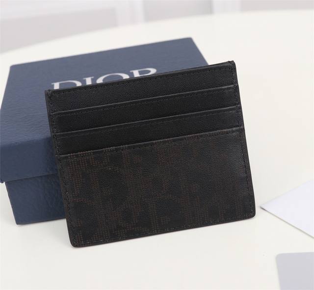 黑色oblique Galaxy印花效果皮革制作 镂空的光滑牛皮革搭配反光里料 细长而小巧的 Dior Oblique 卡夹便于携带卡片和现金 两侧分别设有3个