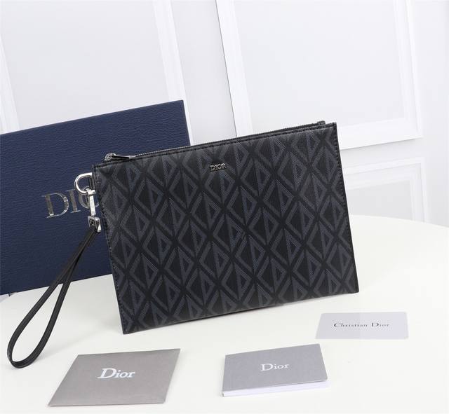 这款 A5 手拿包是一款优雅简约的配饰 采用迪奥灰 Cd Diamond 图案帆布精心制作 从 Dior 档案汲取灵感 饰以同色调光滑牛皮革细节 拉链隔层内设有