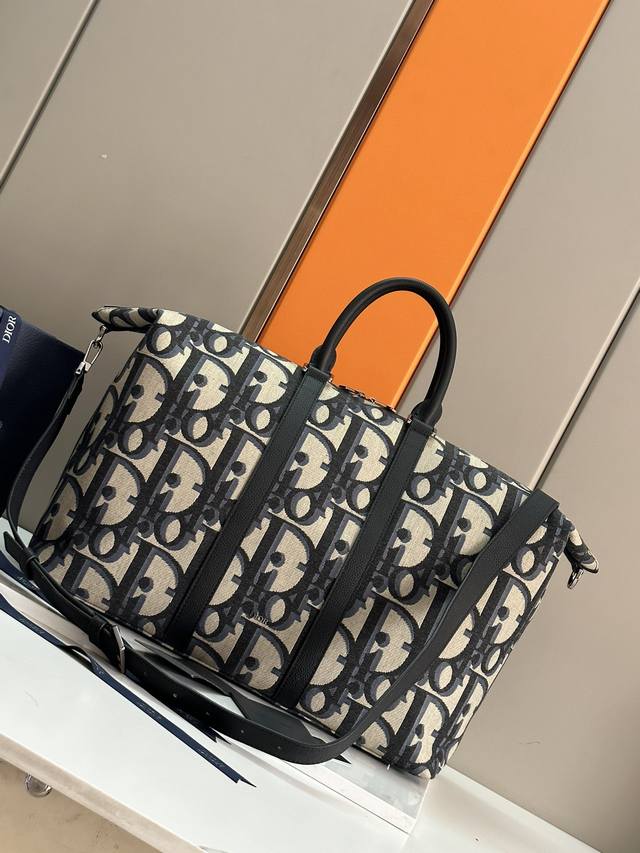这款 Weekender 50 手袋是二零二四春季男装系列新品 彰显经久不衰的高雅风格 采用黑色超大 Oblique 印花面料精心制作 饰以 Dior 标志提升