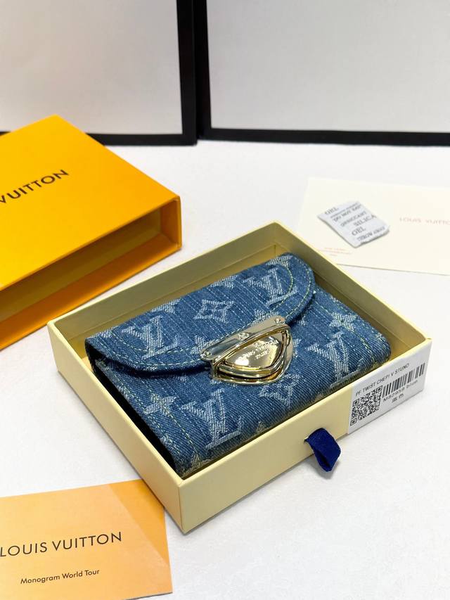 颜色 蓝尺寸 12x9.5x1.5Portefeuille Victorine”采用石洗字母组合牛仔帆布制成，营造出休闲氛围。翻盖带有世家标志性的金色插锁，与缝