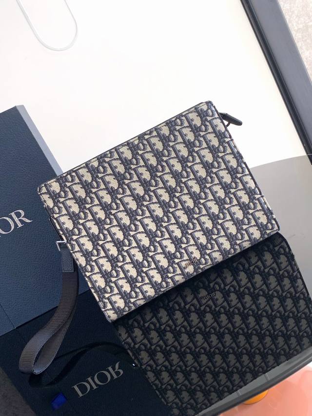 这款手拿包是 Dior 的主打单品。采用米色和黑色 Oblique 印花提花面料精心制作，从 Dior 档案汲取灵感，正面饰以 Dior 标志提升格调。宽敞的拉